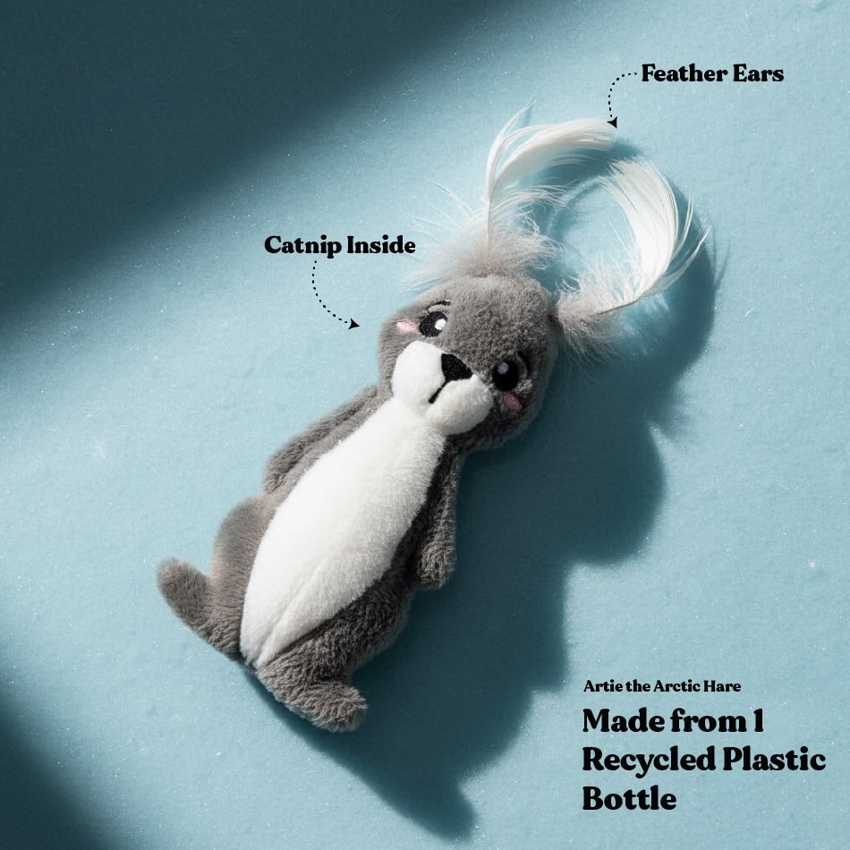 Plush toy resembling an arctic hare with feather ears on a blue background, labeled with features and sustainability information.